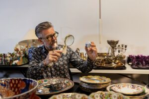 expert appraiser examining antique lamp